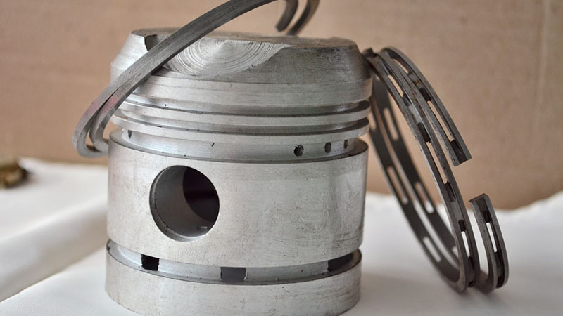 New piston with rings for engine oil control and reduced oil consumption.