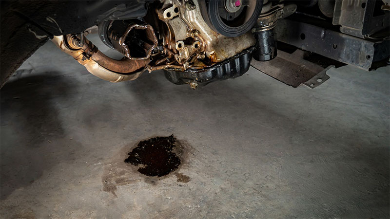 Oil leak visible in car engine.