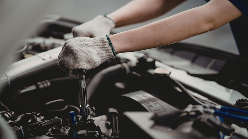 Checking engine oil level in a vehicle to monitor oil consumption.