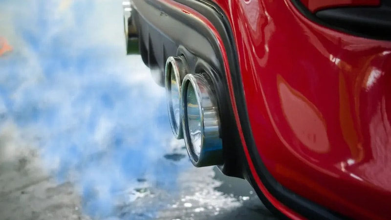 Из выхлопной трубы идет синеватый дым.