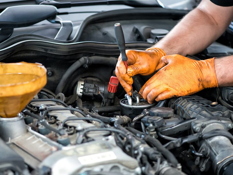 Mechaniker arbeitet während einer Überholung an einem Automotor und sorgt für optimale Leistung und Langlebigkeit.
