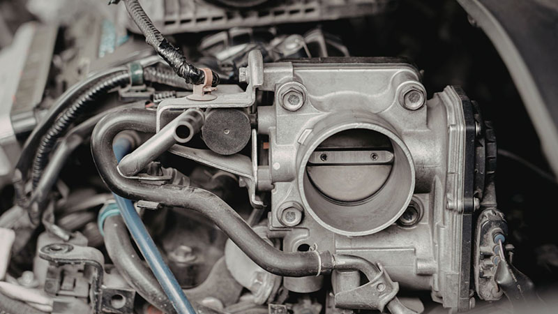 Close-up of a car engine throttle body and intake system.