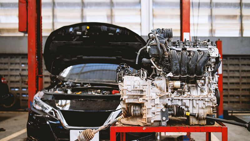 Mechanic performing car maintenance in auto repair workshop.