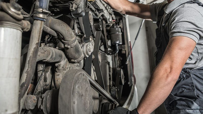 Commercial vehicle diesel engine repair and maintenance being performed by a mechanic.