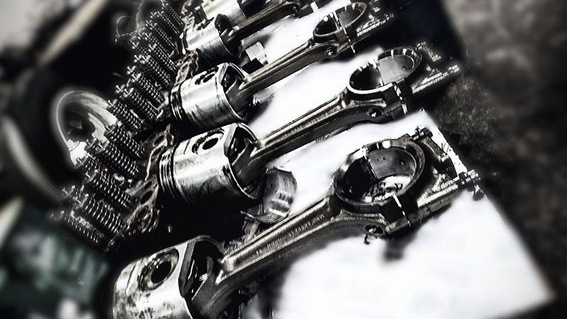 Pistons and engine parts laid out for a diesel engine overhaul.