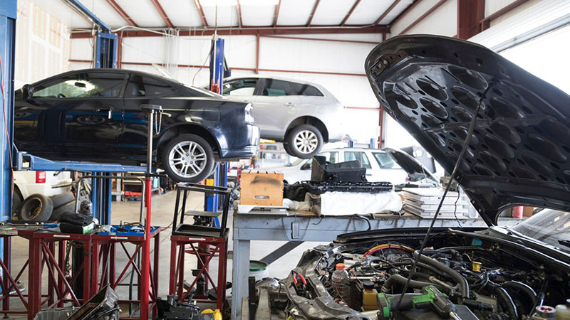 Car hood opened for engine replacement at an automotive repair garage.