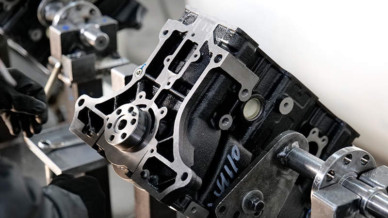 Mechanic inspecting engine on production line at Woda Auto factory.