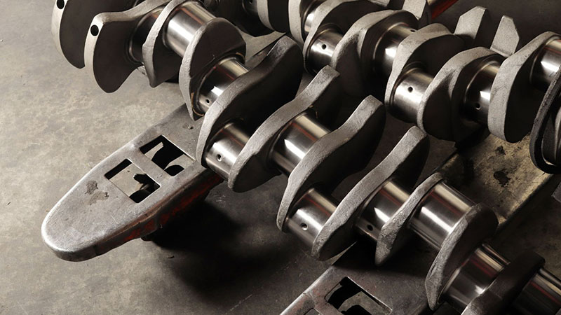 Multiple new engine crankshafts arranged on display showcasing quality and finish.