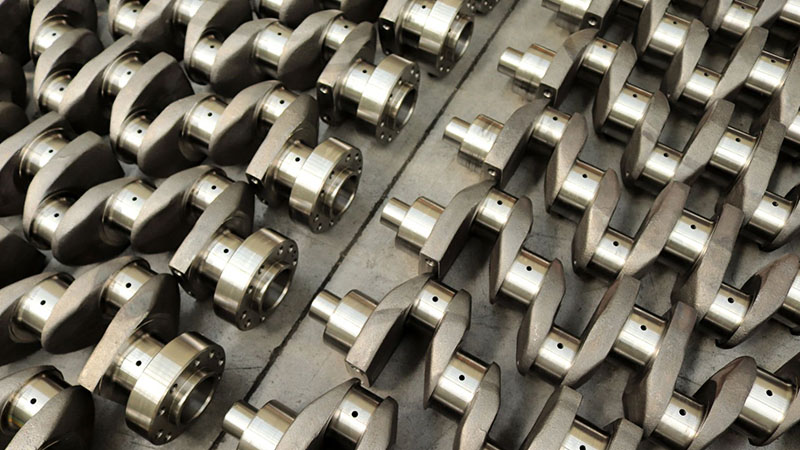 New engine crankshafts displayed in a row ready for assembly or distribution.