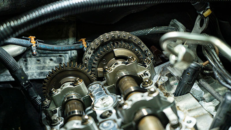 Close-up view of an engine timing chain and sprockets.