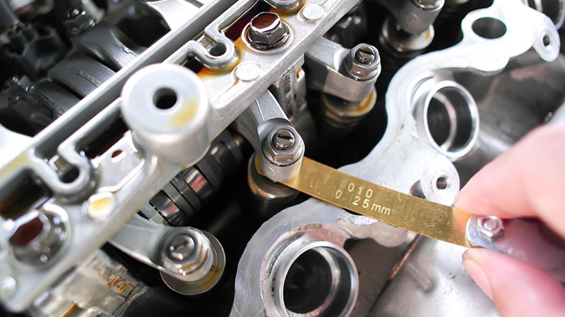 Mechanic inspecting an engine, checking components for maintenance or repairs.