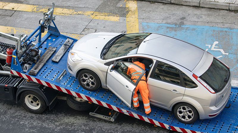 Diesel car mistakenly filled with gasoline being loaded onto a tow truck.