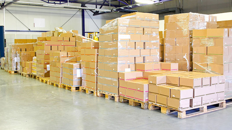 Shipping package in an auto parts warehouse with stacked boxes and pallets.