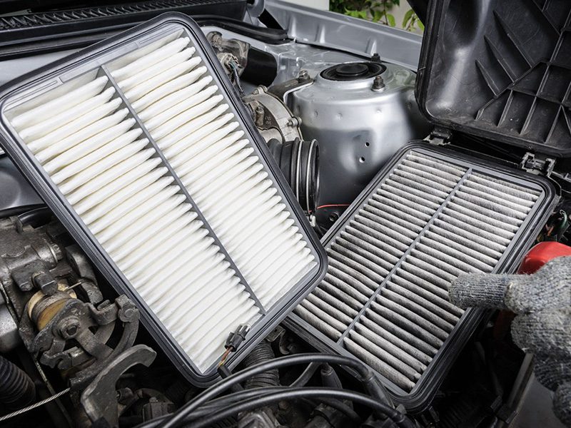 Comparison between a new and used engine air filter for a car.