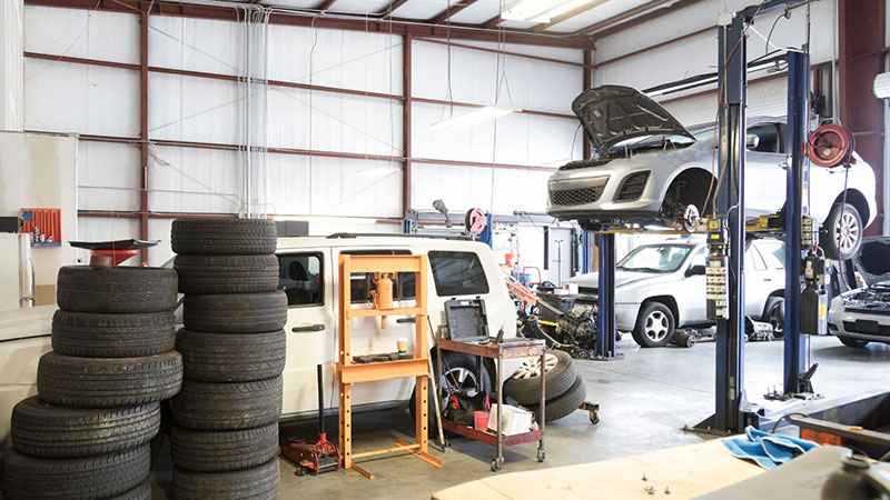 Auto repair garage interior with vehicles and equipment, representing maintenance facilities and after-sales engine support.