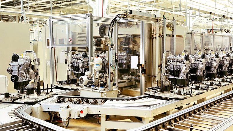 Auto engine assembly line inside a modern factory, showing technicians assembling engines with precision and efficiency.