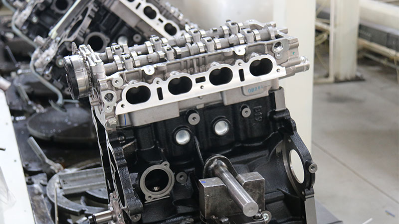 Automotive cylinder head and engine block assembly process at factory production line.