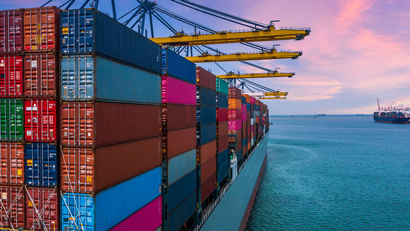 Container ship being unloaded at seaport with cranes for international logistics.