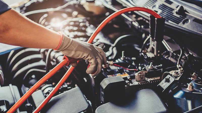 Car maintenance in progress, with a mechanic inspecting or working on the engine or other vehicle components.