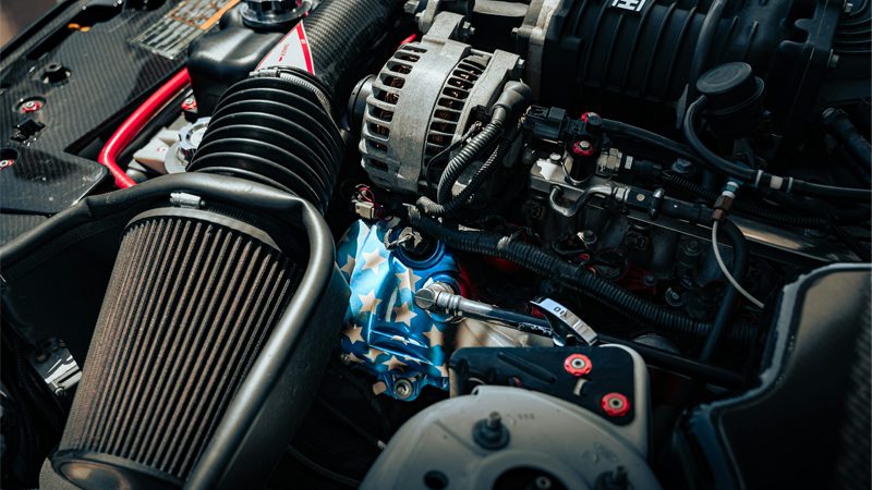 Close-up of a car's engine, highlighting the intake manifold and its critical role in optimizing engine airflow and performance.