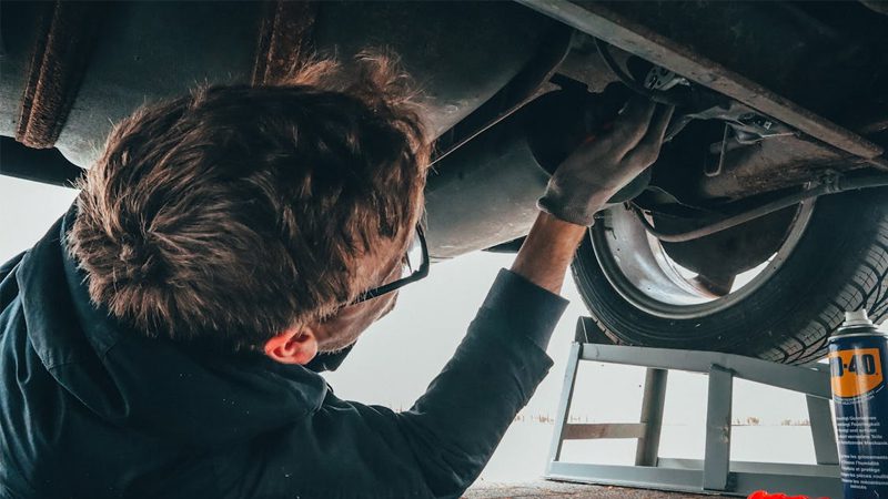 A mechanic working on a car, showcasing the hands-on expertise involved in vehicle maintenance and repair.