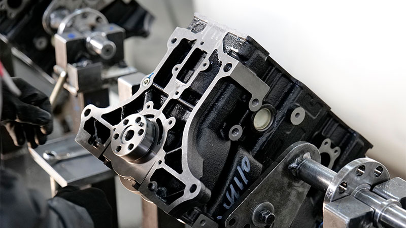 Close-up of engine assembly line at Woda Auto manufacturing facility.