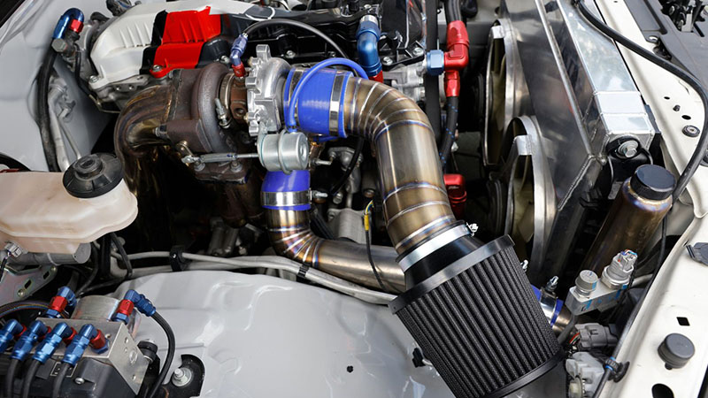 Turbocharger and wastegate installed on a high-performance race car engine.
