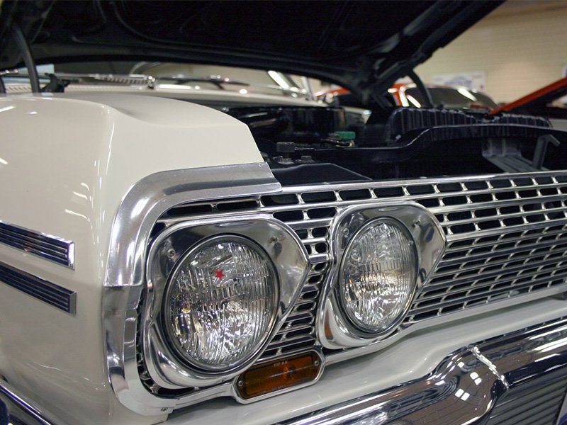 Close-up of a Chevy muscle car with hood open showcasing the engine.