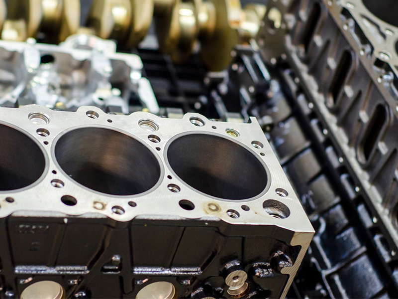 Close-up of a new engine cylinder block showing cylinder bores and machined surfaces, related to low engine compression issues.