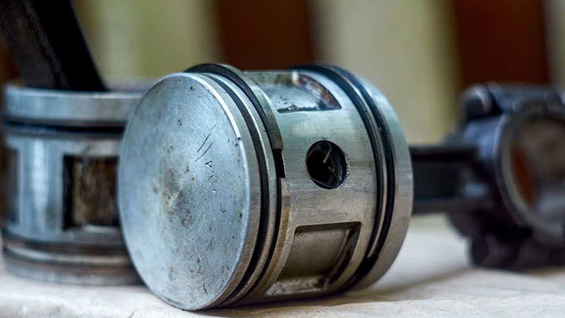 Worn piston and ring assembly contributing to engine compression loss.