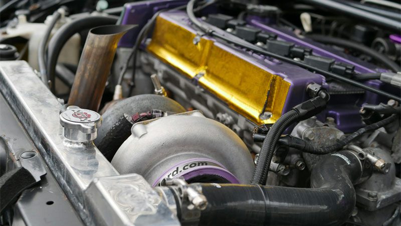 Una fotografía de enfoque superficial del compartimiento del motor de un automóvil negro y gris.