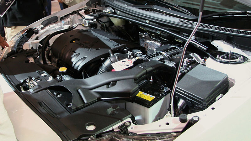 Close-up view of a Mitsubishi 4G15 engine installed under a car’s hood.