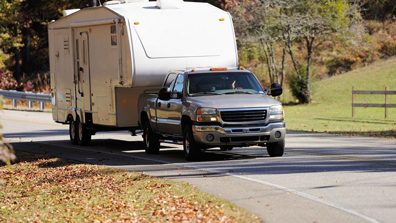 Close-up of a pickup truck towing a heavy load – Demonstrating how towing capacity can impact fuel economy and performance.
