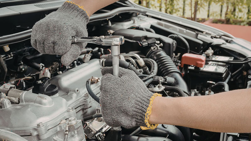 Mechanic working on a car engine during routine maintenance.