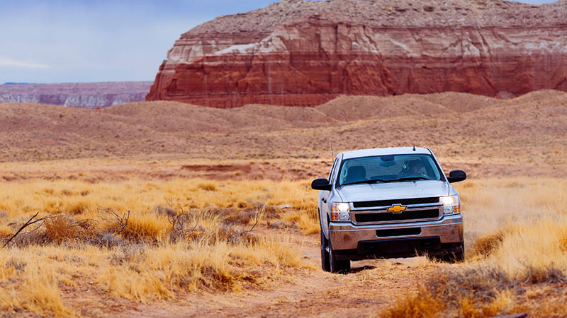 White Chevrolet vehicle driving in the desert.