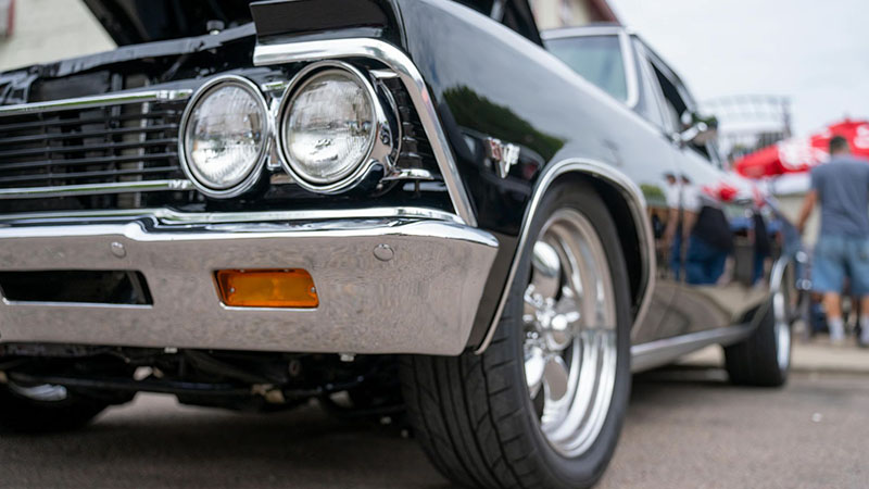 Close-up of a black Chevrolet Chevelle with the hood open.