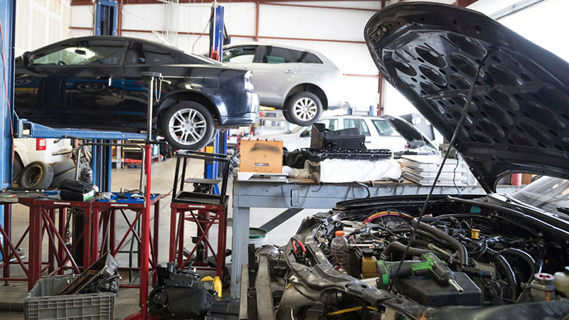 Car engine replacement at an auto repair garage.
