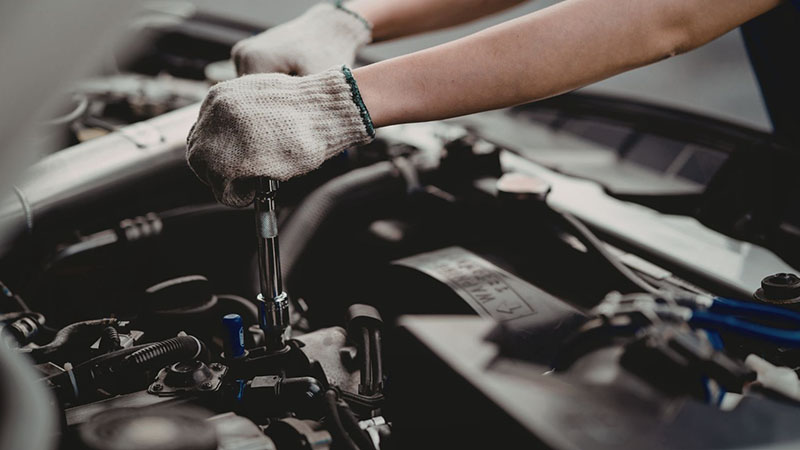 Checking engine oil level in vehicle during routine engine maintenance.