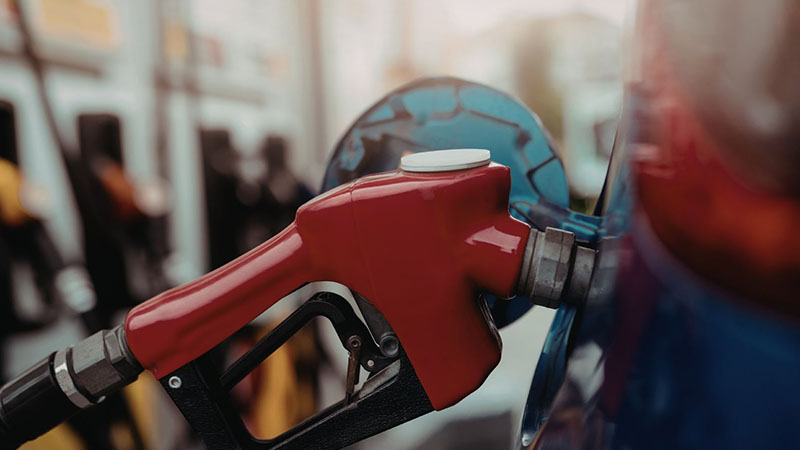 Red gas pump at fuel station used for vehicle refueling.