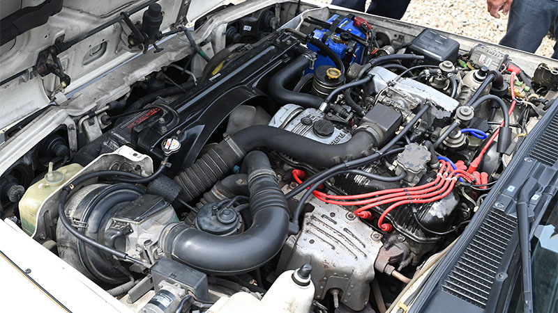Modern engine under car hood with visible engine components.