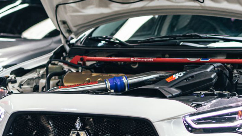 Крупный план двигателя Mitsubishi, установленного под капотом автомобиля.