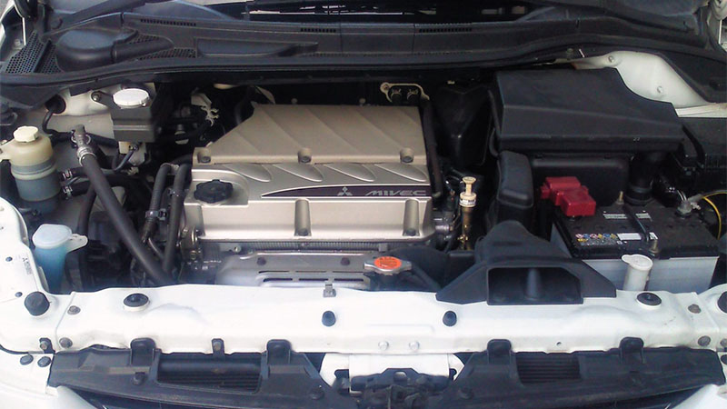 Крупный план бензинового двигателя Mitsubishi 4G69 MIVEC объемом 2.4 л, рядного четырехцилиндрового.