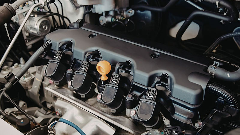 Car engine with ignition coil highlighted for diagnosis.