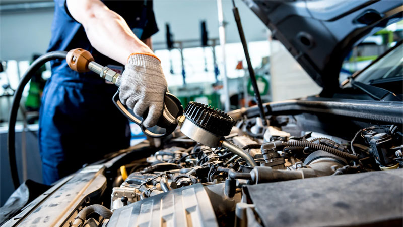 Car mechanic changing engine oil during maintenance at service station – engine repair and oil pump care.