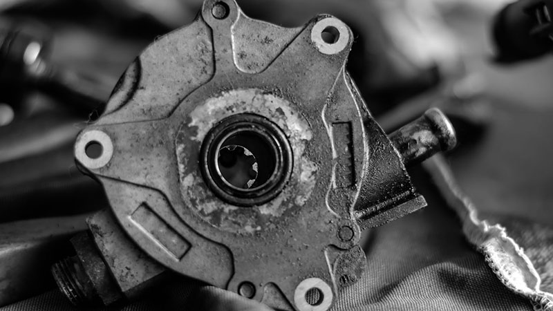 Close-up of an old dirty automotive vacuum oil pump – worn engine part before replacement.