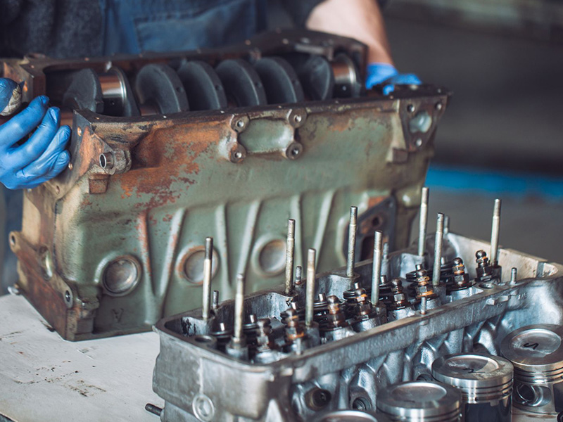Mechanic preparing a rebuilt engine for installation in a car.