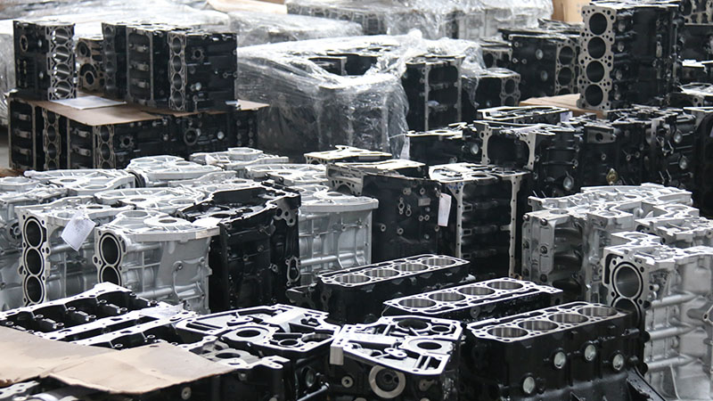 Bulk remanufactured engine parts lined up in a factory warehouse.