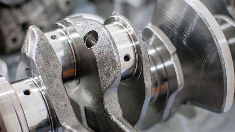 Close-up of a crankshaft showing detailed machining and surface finish