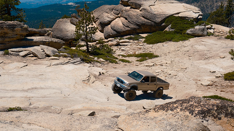 Toyota Tacoma driving on rough terrain off-road.