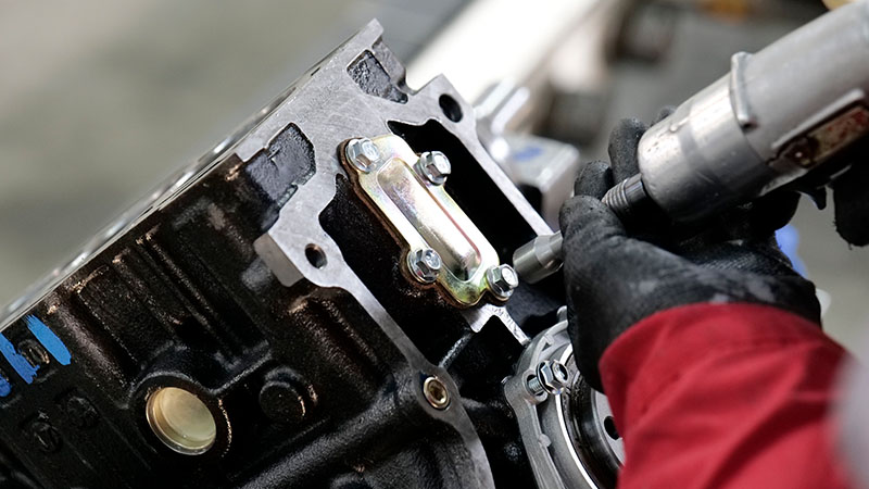 Mechanic assembling engine at Woda Auto factory production line.